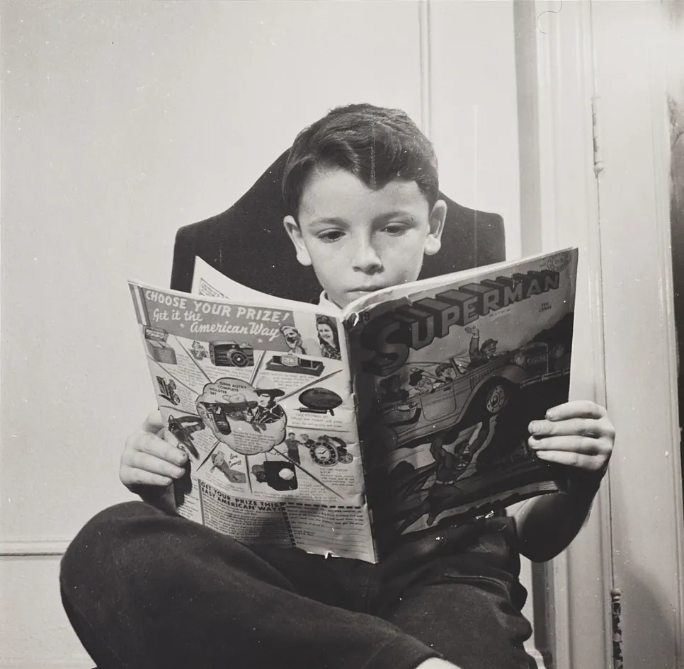 A boy reading a comic book in a photograph taken in 1942